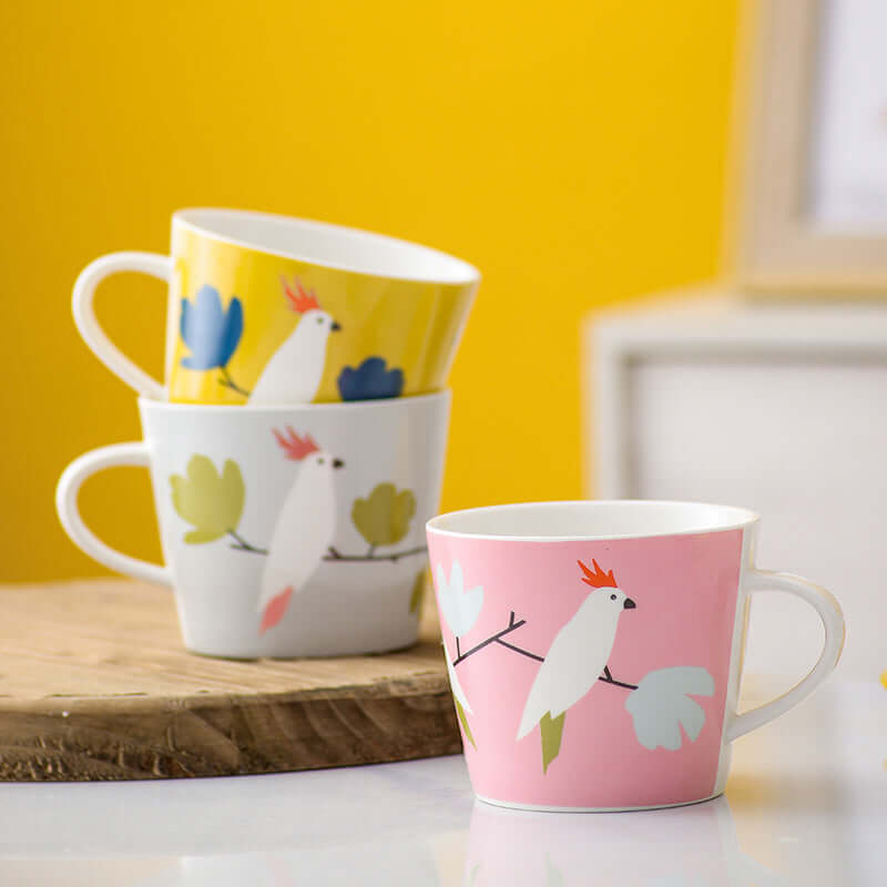 Nordic style ceramic mugs in white, pink, and yellow with parrot design, perfect for coffee. Capacity 301-400mL.